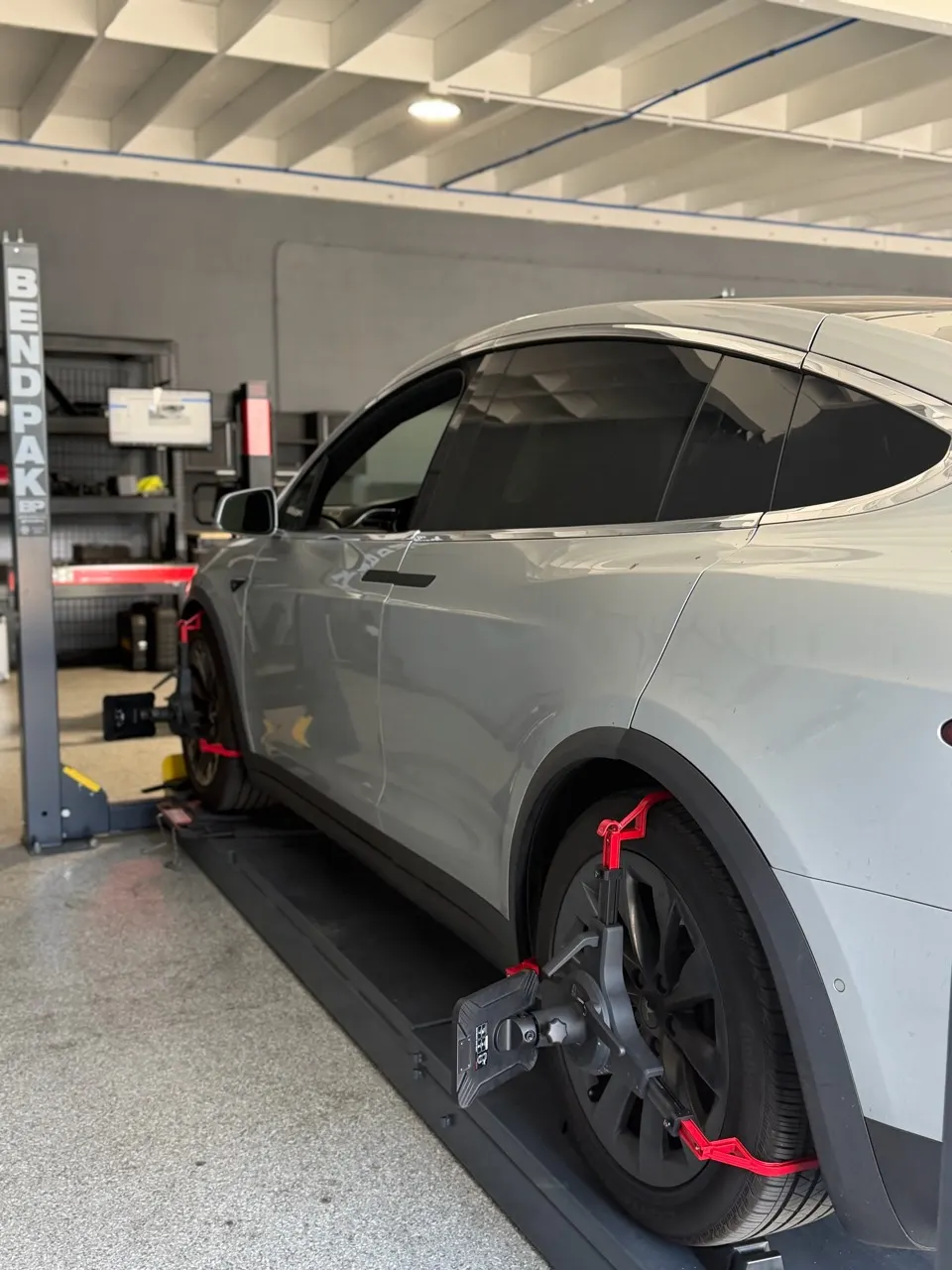 Tesla Model X on the alignment rack with wheel-mounted measuring targets