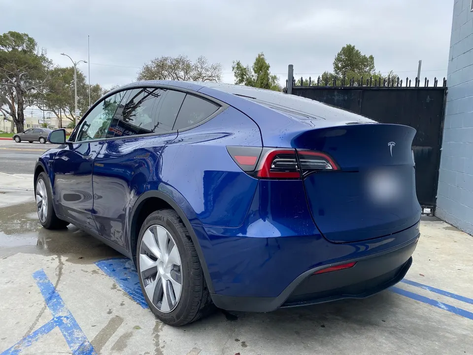 Blue Tesla Model Y photographed after exterior repair work